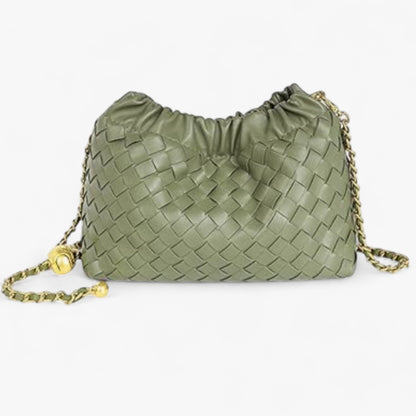 Close-up of a small Intrecciato-style green handbag featuring a ruched top and gold chain shoulder strap.