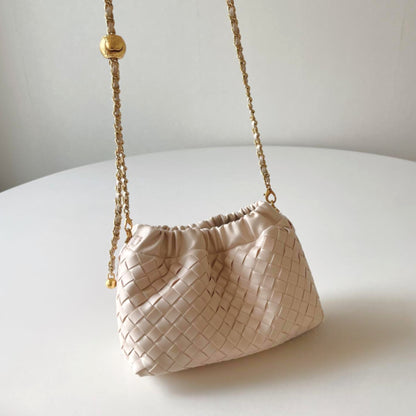 An everyday casual cream-coloured hand-woven shoulder bag with a gold chain strap on display.