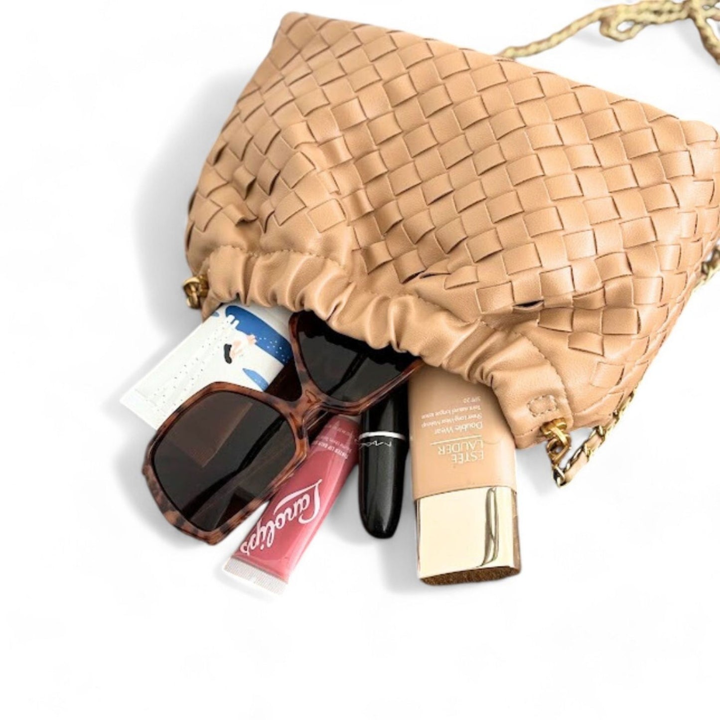 Tan woven pattern bag lies flat with its content spilling out.