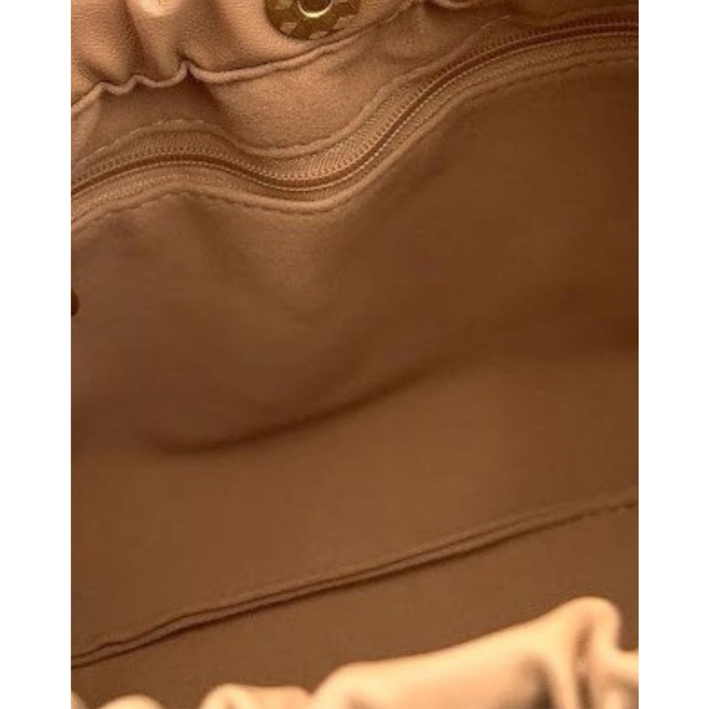 Interior of a bag in tan with a zip pocket and velvet lining.