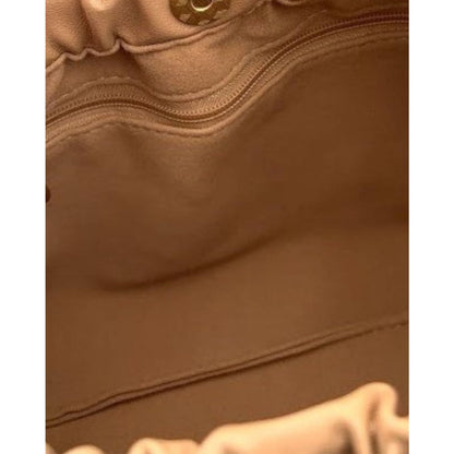 Interior of a bag in tan with a zip pocket and velvet lining.