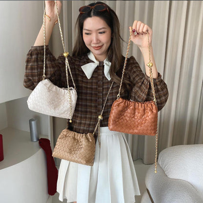 Woman modeling three Intrecciato-style shoulder bags to showcase the size and chain strap length.