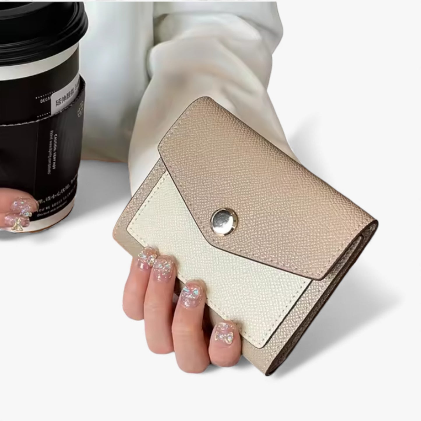 Compact cream-and-beige Epsom-textured vegan leather wallet with a silver front snap button.
