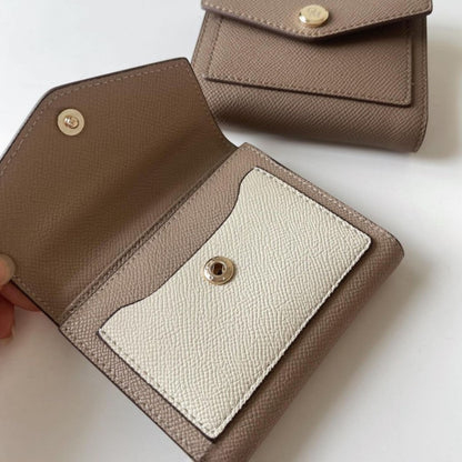 Beige/Cream and khaki wallets with envelop-style flap, and smooth gold button, shown side by side.