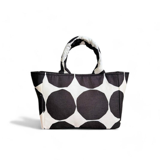 Mini tote bag with rows of big black polka dots on white background .