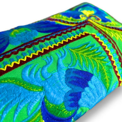 Close-up of handmade Green Peacock wristlet showing intricate Hmong embroidery with vibrant blue and green.