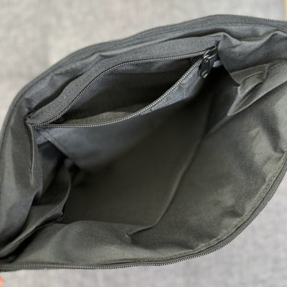Interior view of a bag with black lining and a zip pocket.