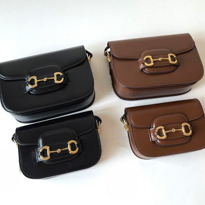 A black and a brown medium leather bag, and a black and a brown small leather bag, lying side by side.