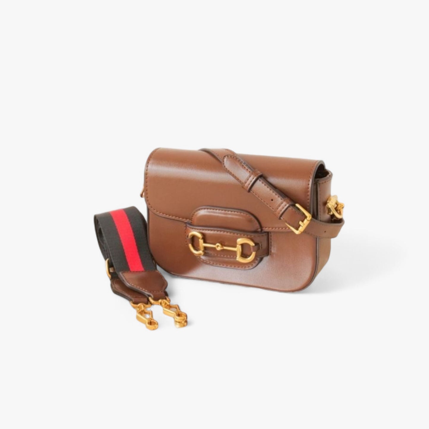 A timeless brown leather bag with gold accents, featuring a slim, smooth leather strap and a wide nylon strap.