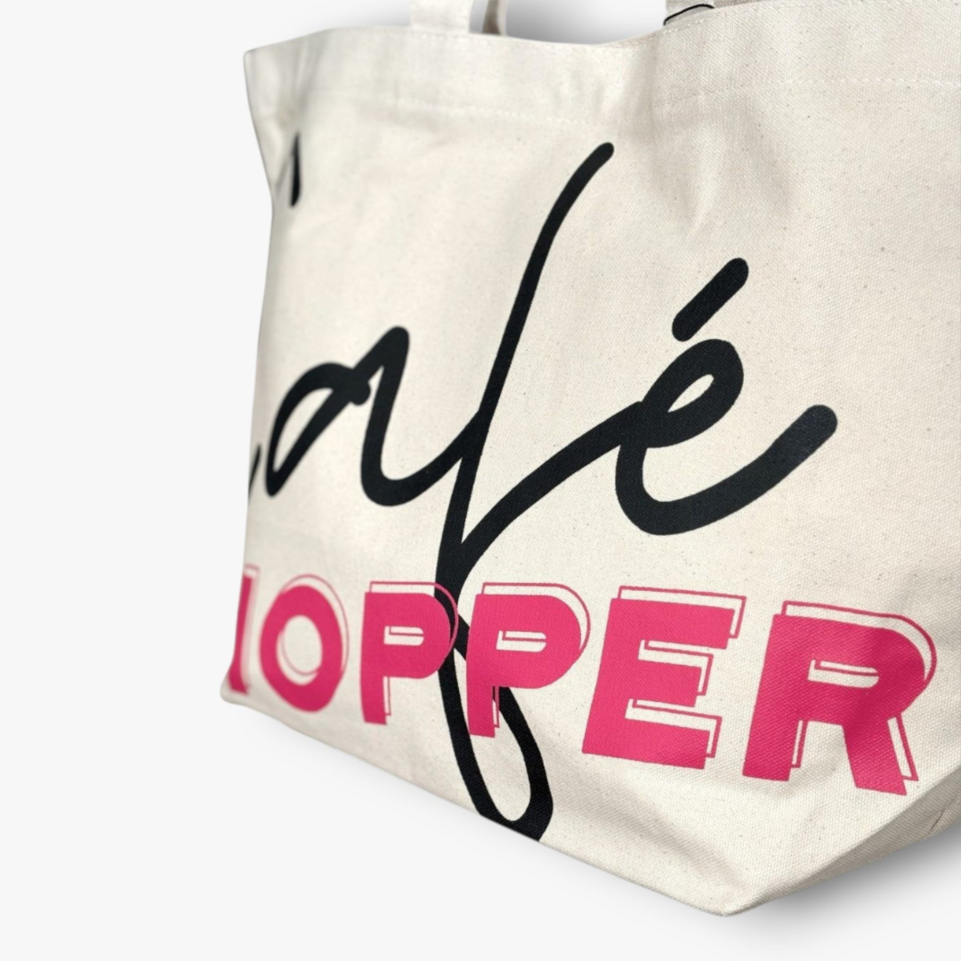 Detail shot of Café Hopper tote highlighting trendy lettering print on durable canvas.