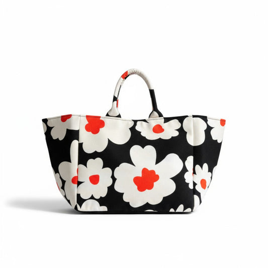 Front view of Shopper Bag Daisy Pop, an oversized black tote featuring bold white daisies with orange centres.