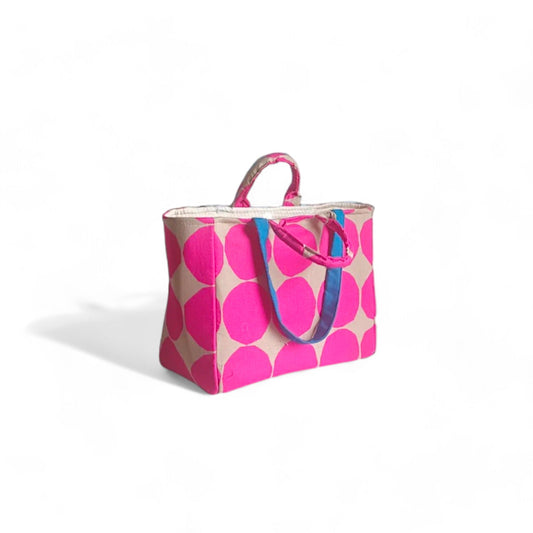 A stylish shopper tote bag with a bold hot pink and tan polka-dot pattern.